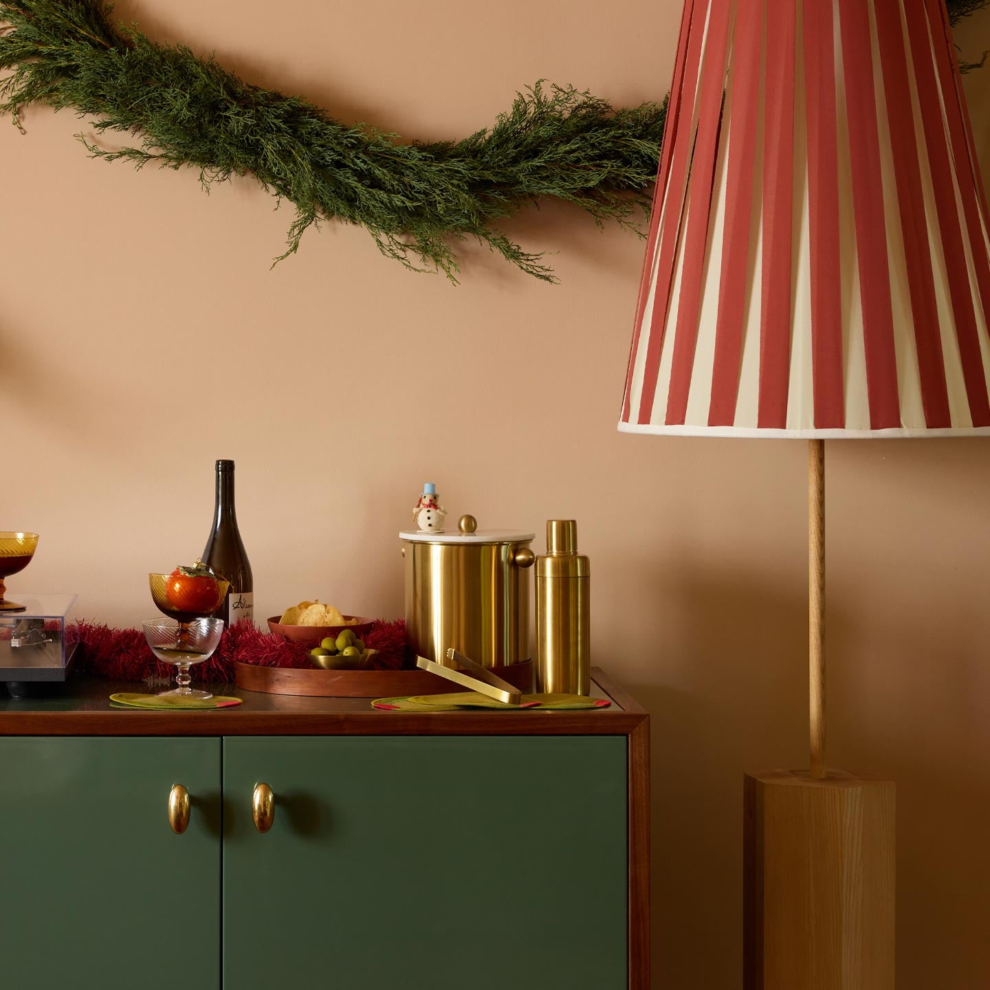 Home bar with large lamp and juniper garland.