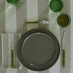 Placesetting with Essential Striped Dinner Napkin in Olive and Sage on Striped Olive tablecloth.