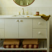 Bathroom vanity with striped towels and waffle towels and a candle on the counter.