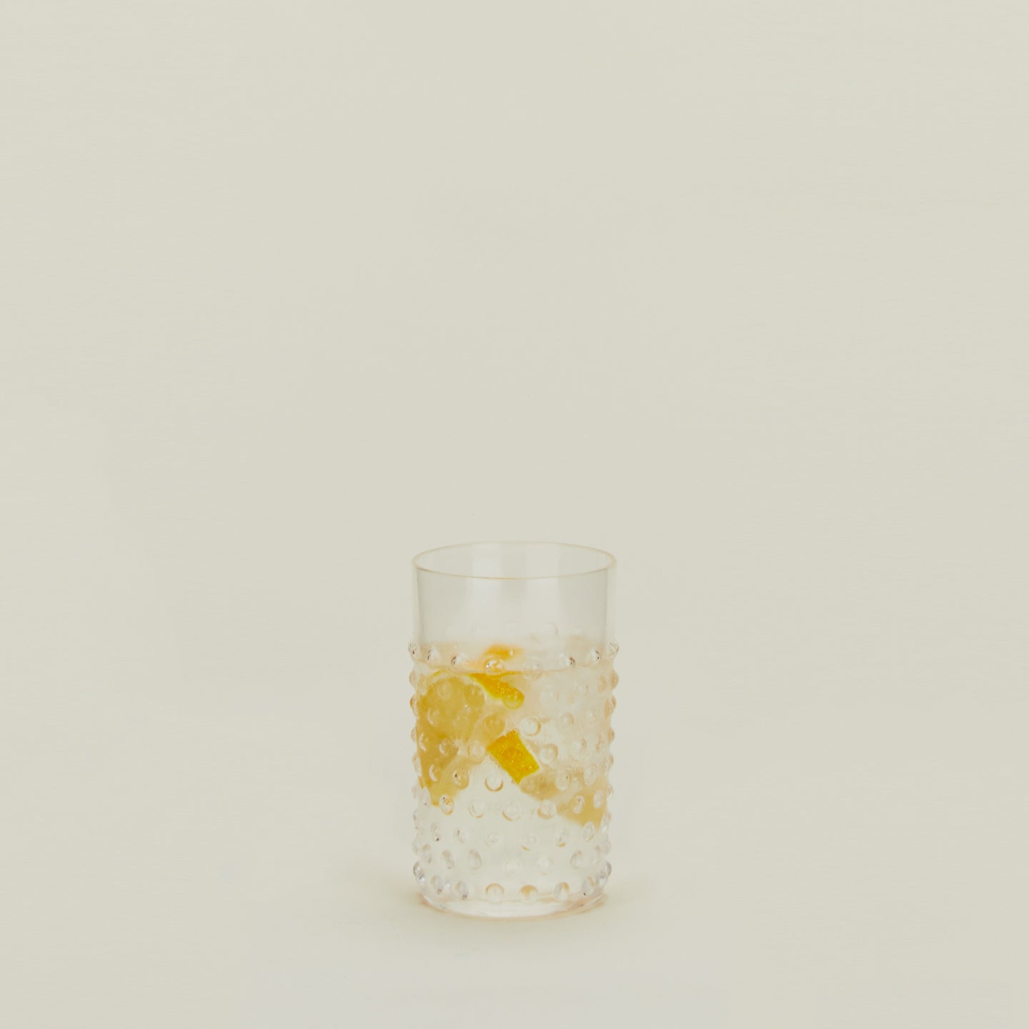 Hobnail Tumbler in Clear filled with water and fruit.