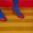 Red high-heeled shoes with blue toes Essential Floor Runner in Mustard with red background.
