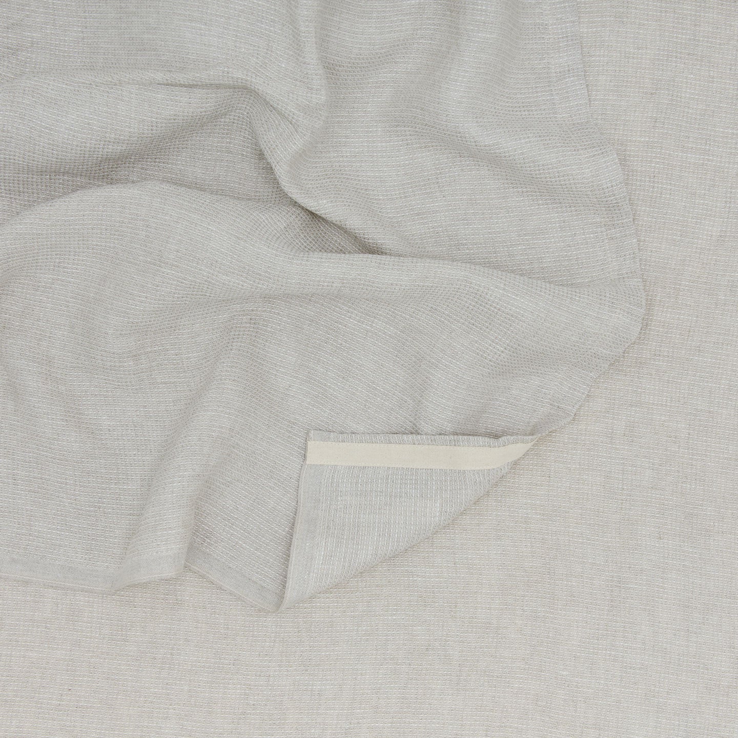 A Linen Washed Waffle Throw Blanket in natural.