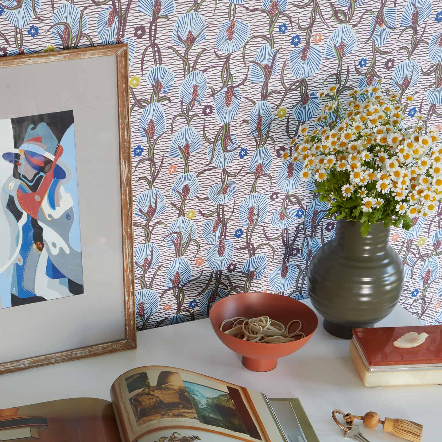 Essential Ceramic Vase in Olive with flowers on desk with wallpaper.