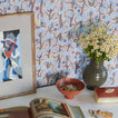 Essential Ceramic Vase in Olive with flowers on desk with wallpaper.