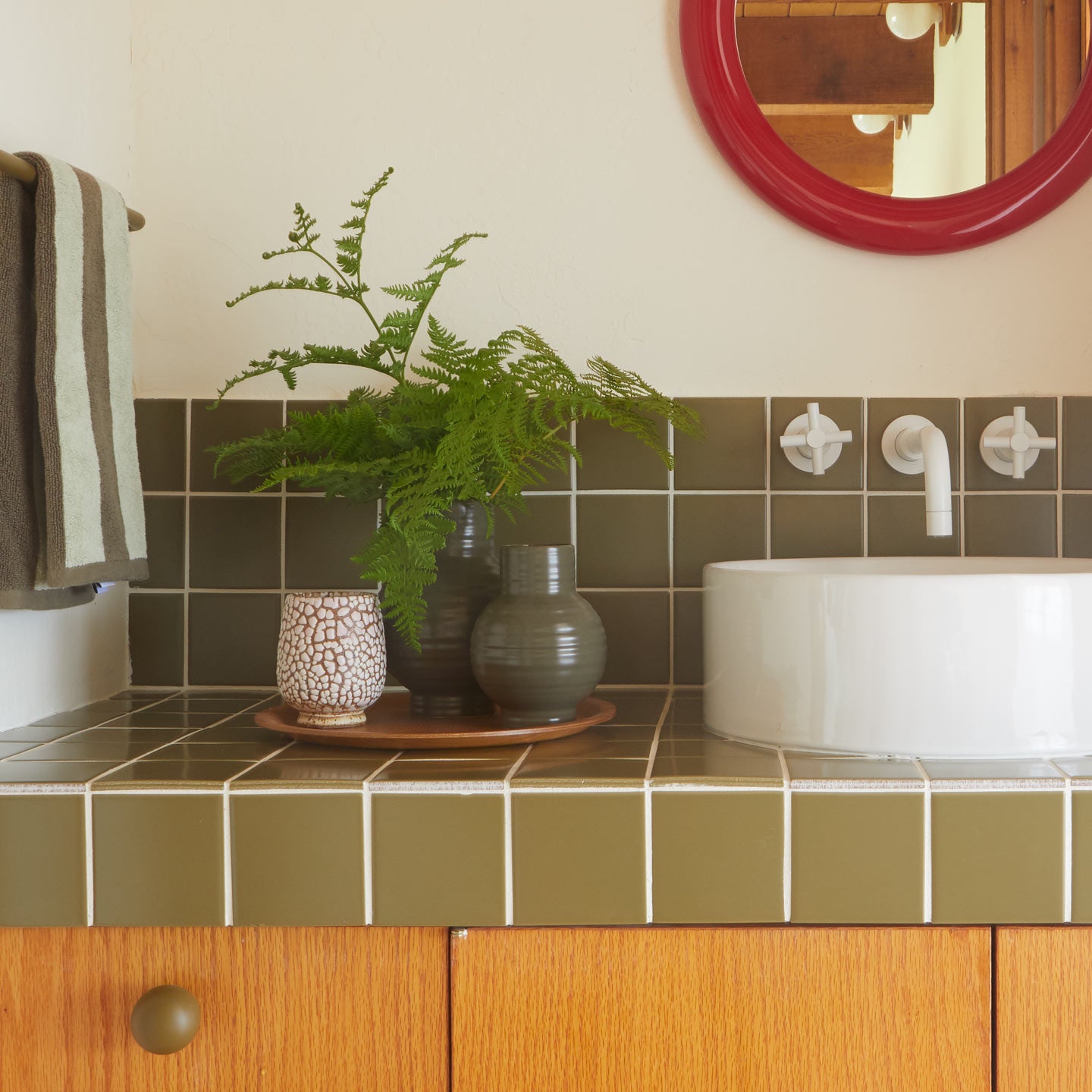 Essential Ceramic Vase in Olive with ferns on bathroom counter.
