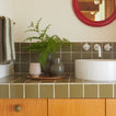 Essential Ceramic Vase in Olive with ferns on bathroom counter.