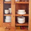 Cabinet with Simple Porcelain Dinnerware and Gingham Napkins.