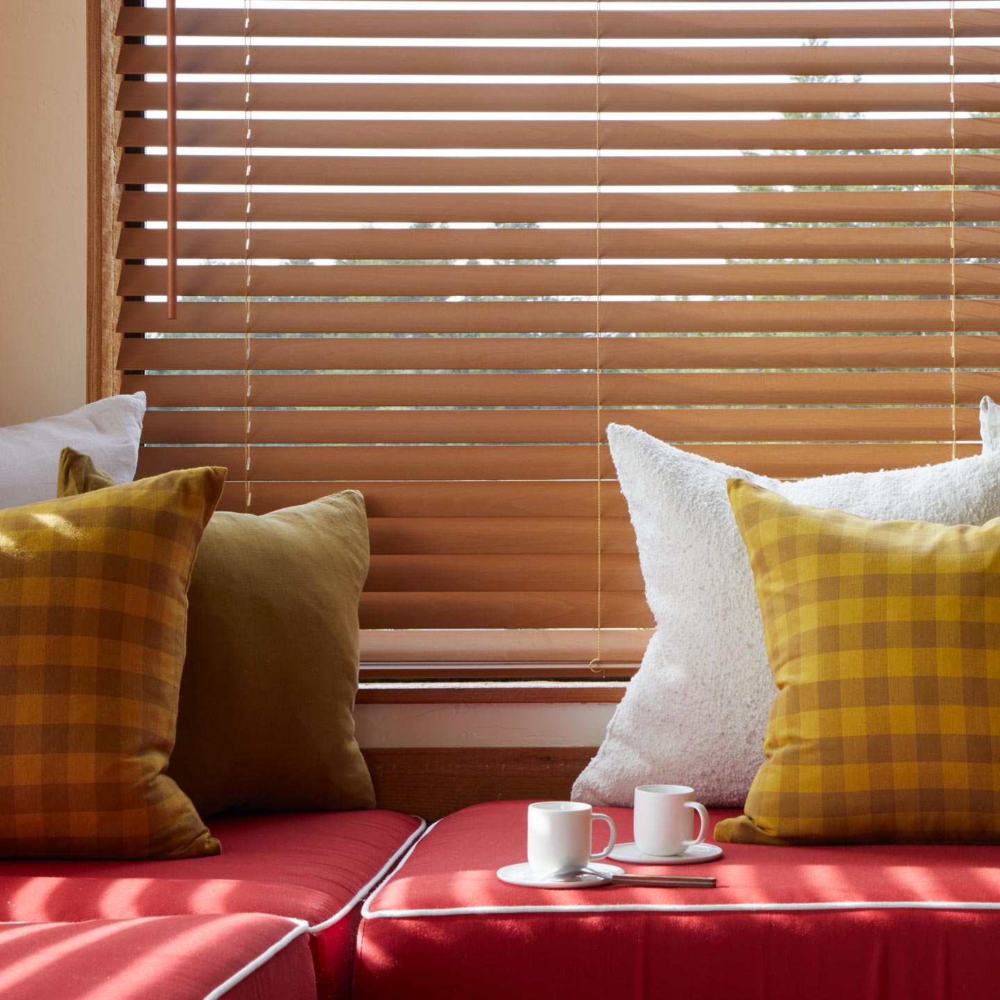 Sofa with pillows including Essential Gingham Pillow in Mustard with espresso mugs. 