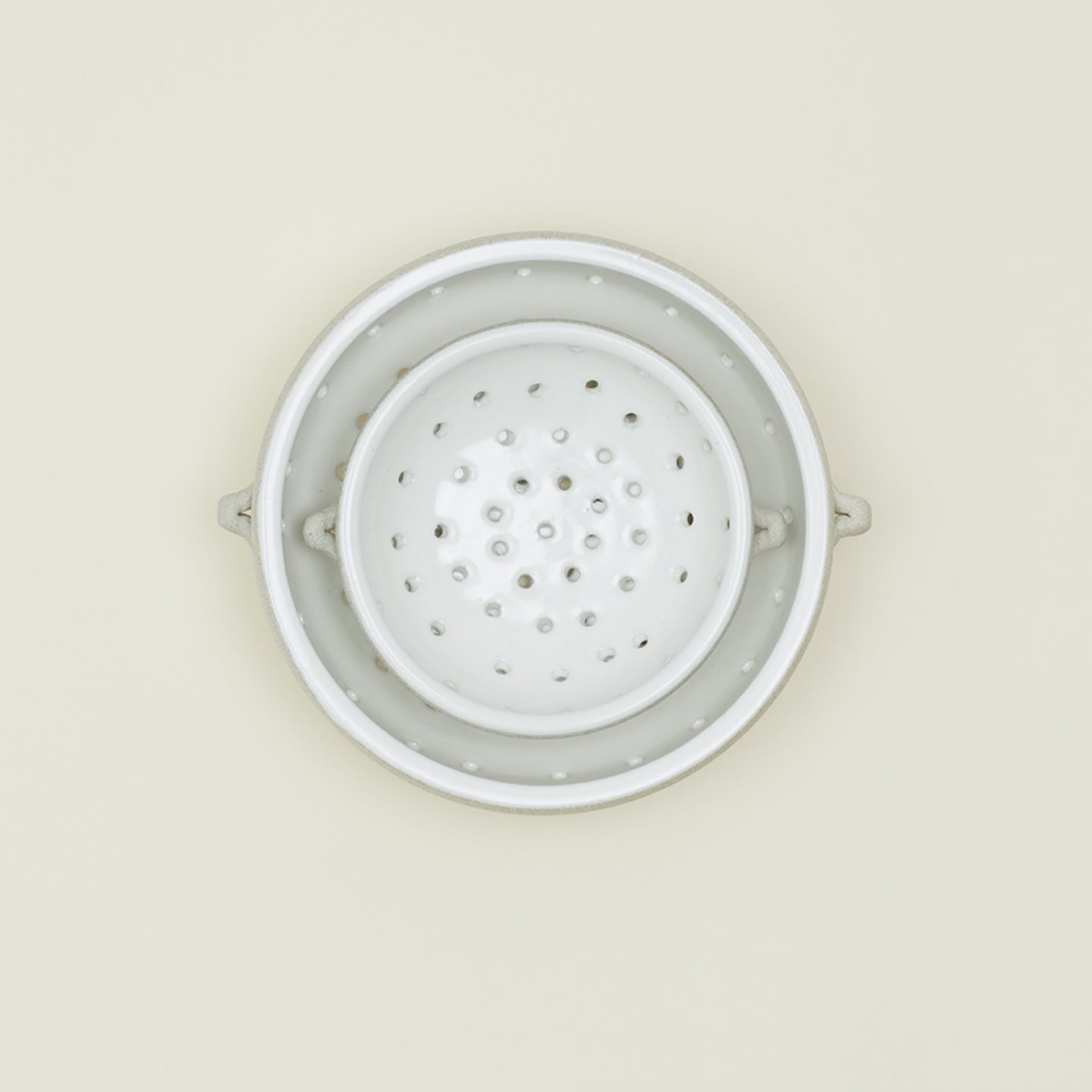 Overhead view of large and small colander nested 