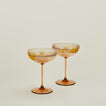 Set of two ribbed brown coupe glasses with cocktail.