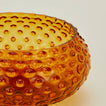 Close up of glass hobnail amber serving bowl.