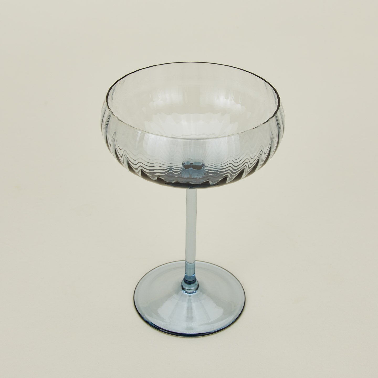 Three-quarter angle of ribbed blue coupe glass.