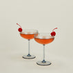 Set of two ribbed blue coupe glasses with cocktail.