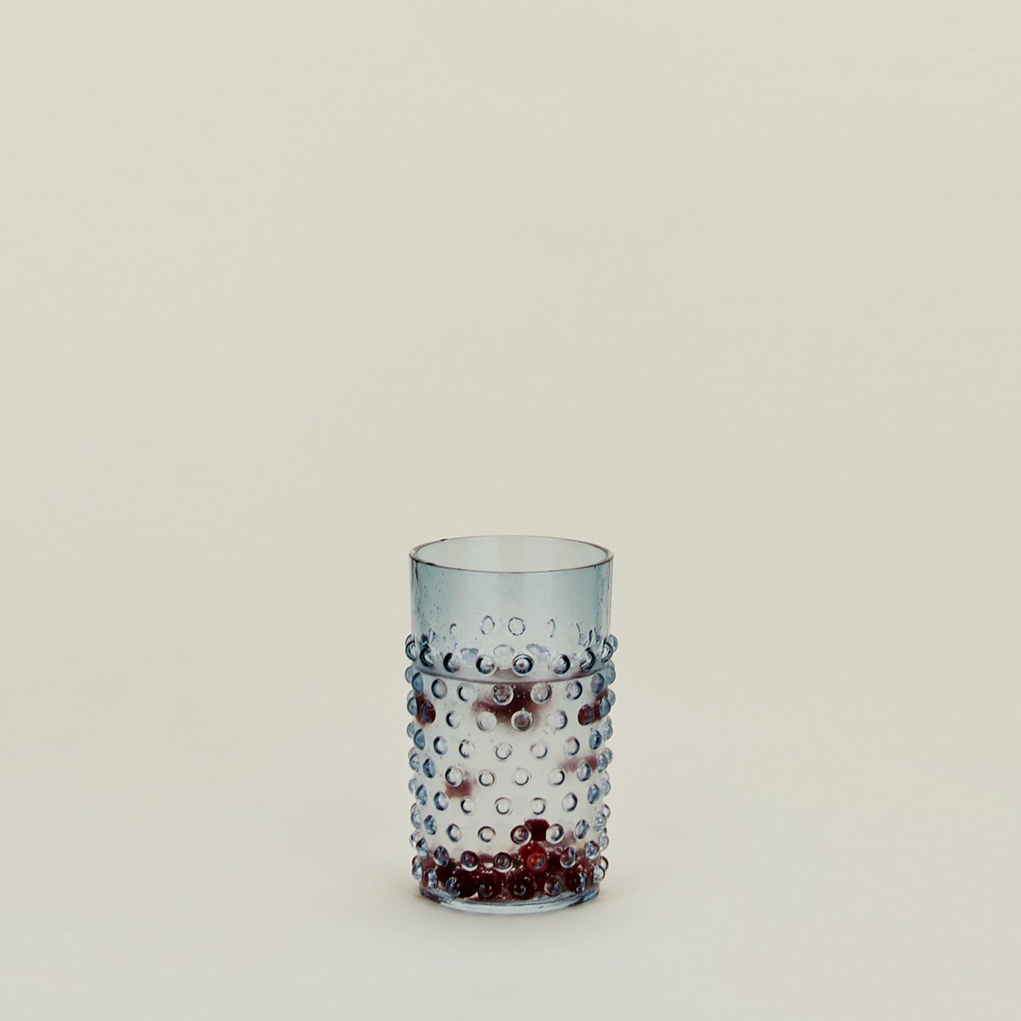 Hobnail Tumbler in Blue filled with water and fruit.