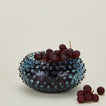 Glass hobnail blue serving bowl with grapes.