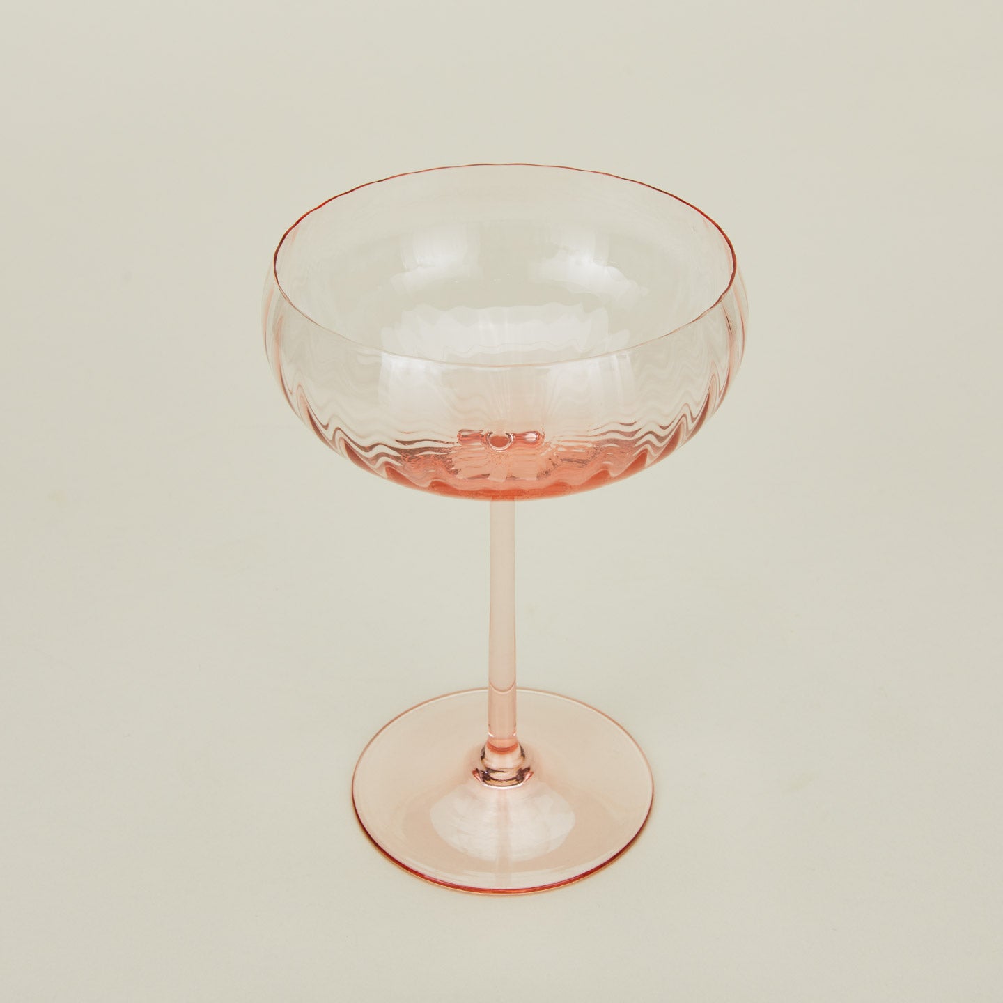 Three-quarter angle of ribbed blush coupe glass.