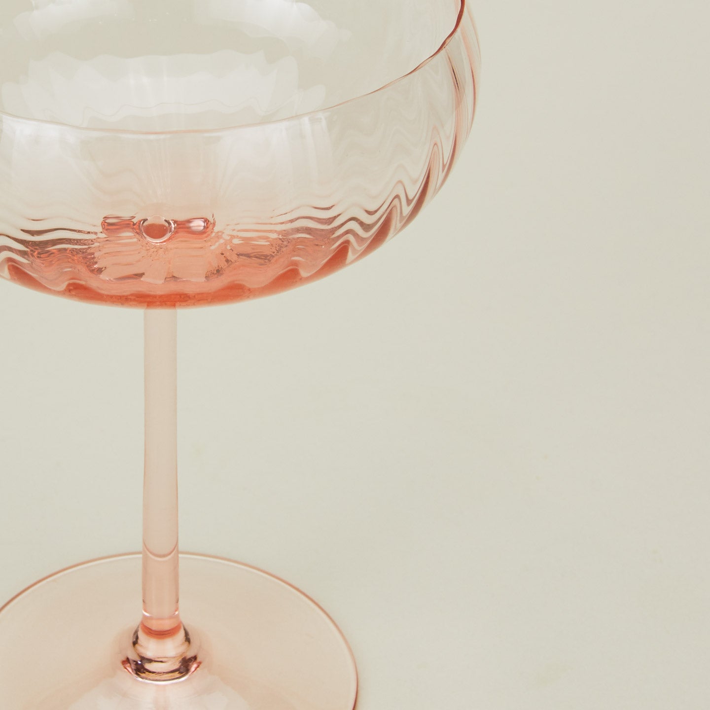 Close up of ribbed blush coupe glass.