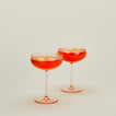 Set of two ribbed blush coupe glasses with cocktail.