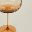 Close up of ribbed brown coupe glass.