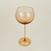 Three-quarter angle of ribbed brown wine glass.