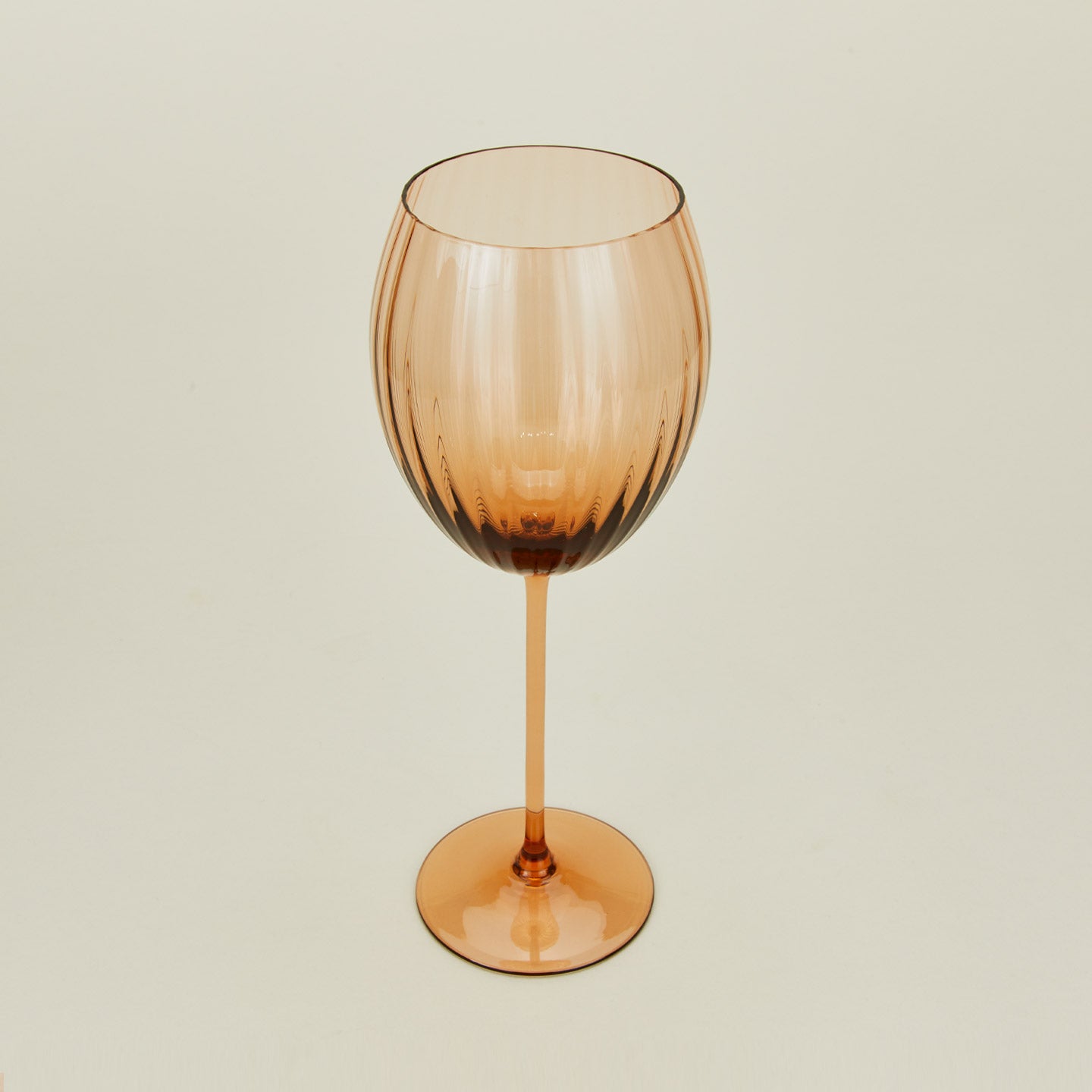 Three-quarter angle of ribbed brown wine glass.