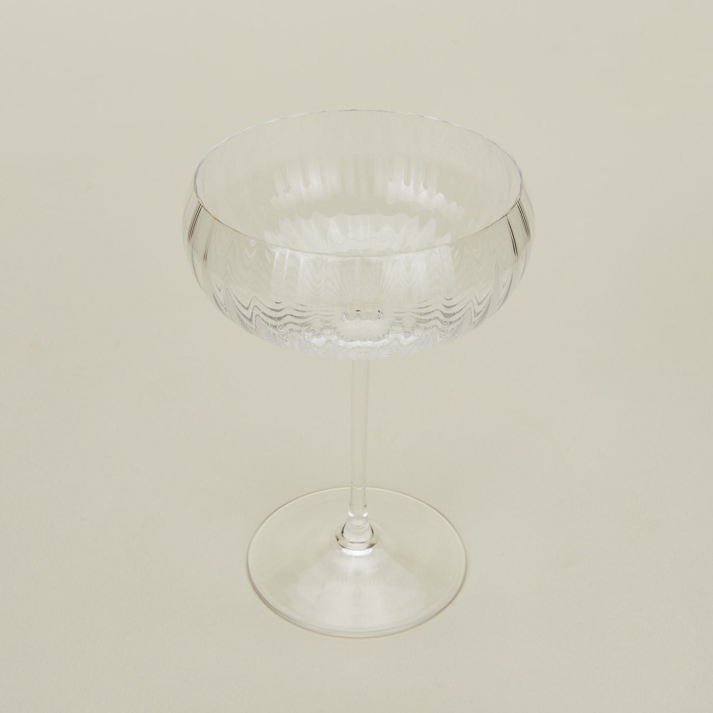 Three-quarter angle of ribbed clear coupe glass.