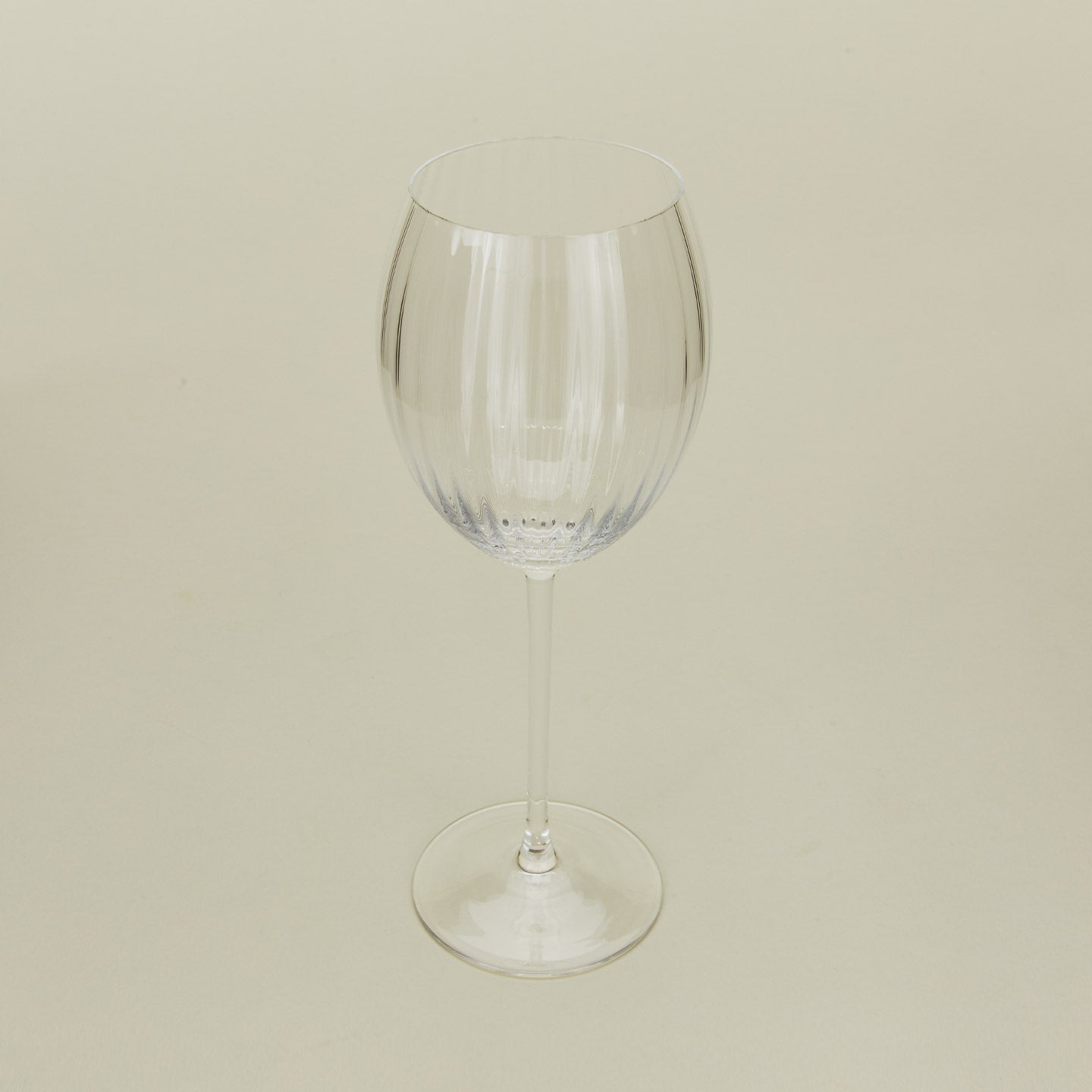 Three-quarter angle of ribbed clear wine glass.