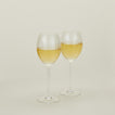 Set of two ribbed clear wine glasses with white wine.