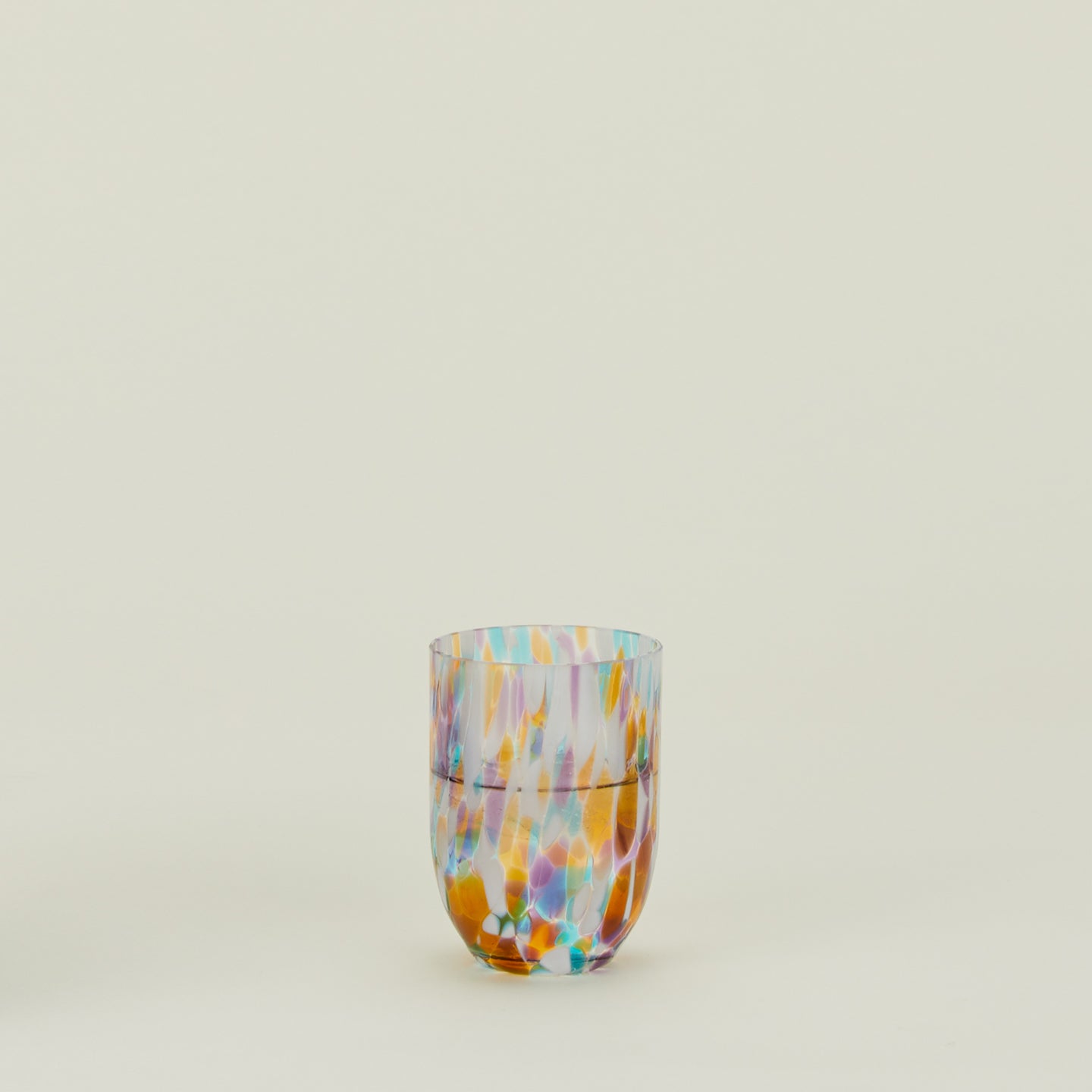 Multi-color glass tumbler filled with water.