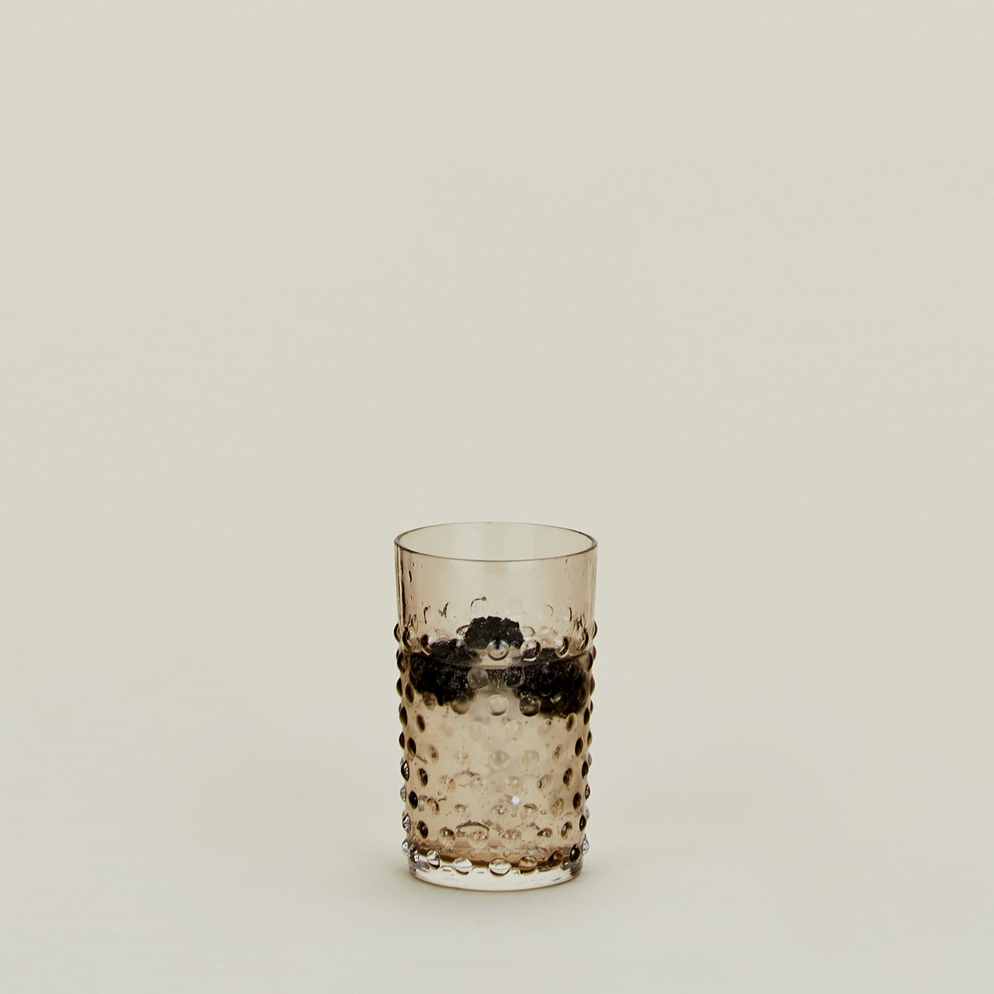 Hobnail Tumbler in Grey filled with water and fruit.