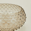 Close up of glass hobnail grey serving bowl.
