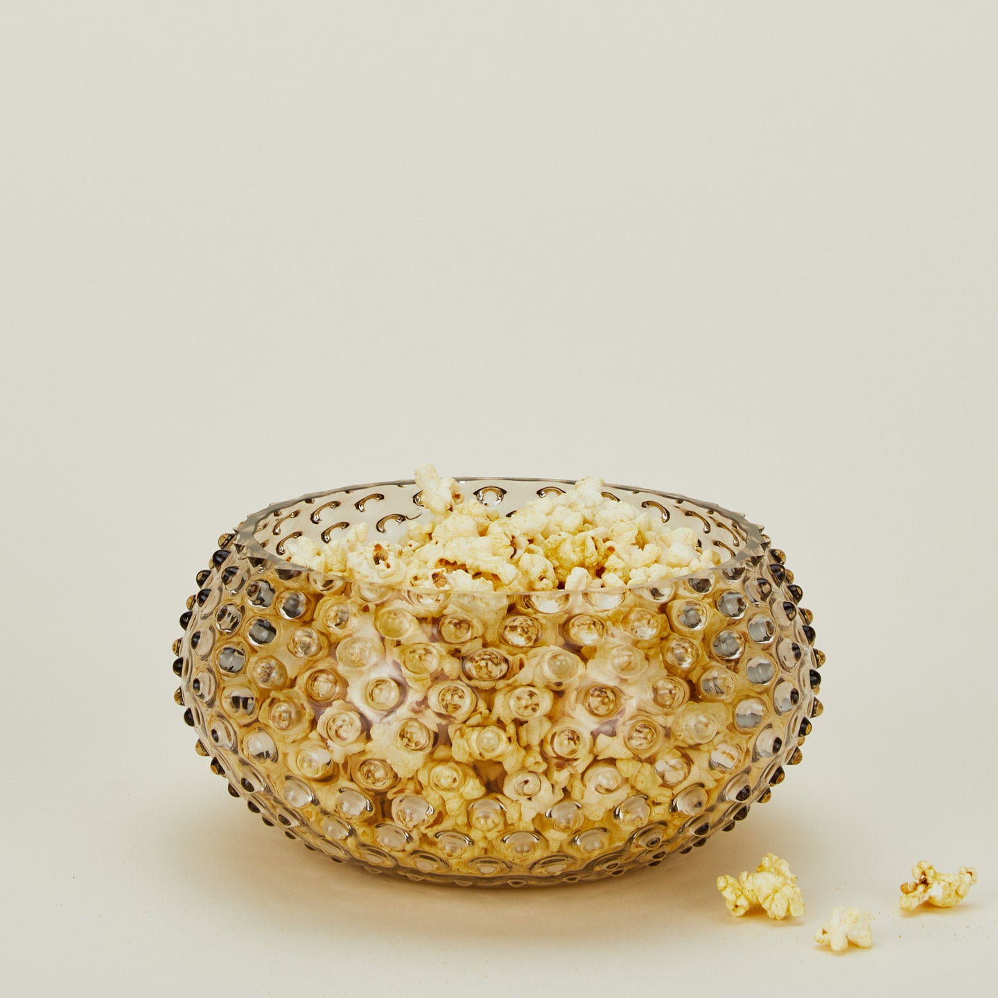 Glass hobnail grey serving bowl with popcorn.