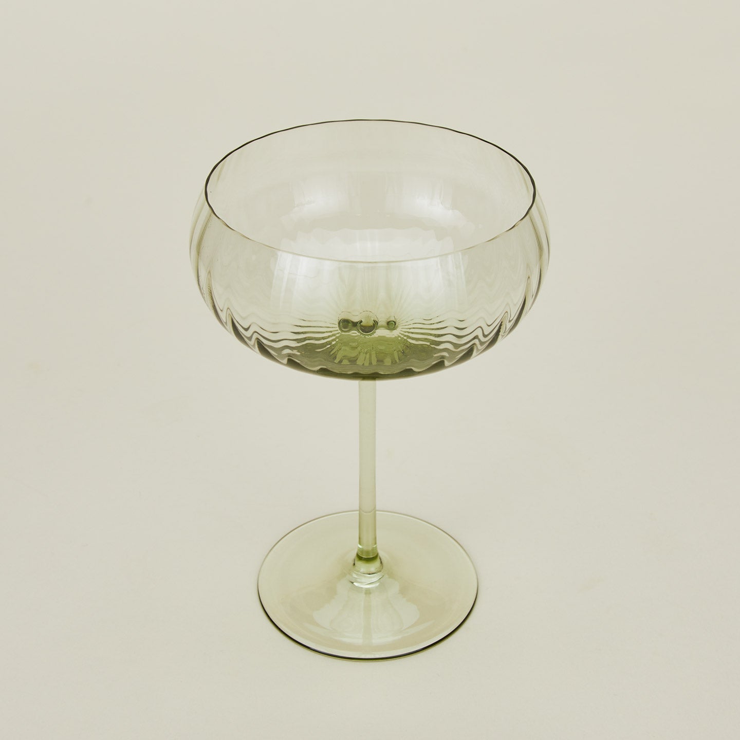 Three-quarter angle of ribbed olive coupe glass.