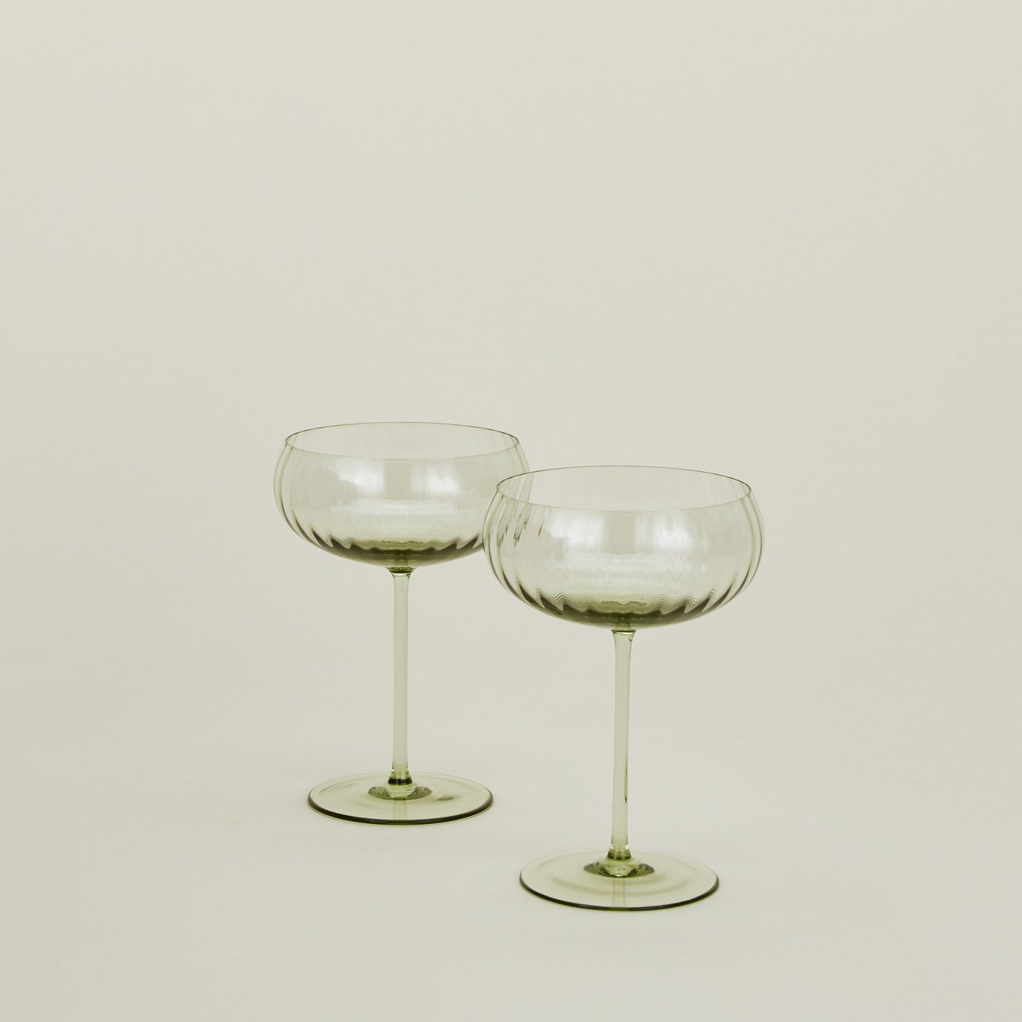 Set of two ribbed olive coupe glasses.