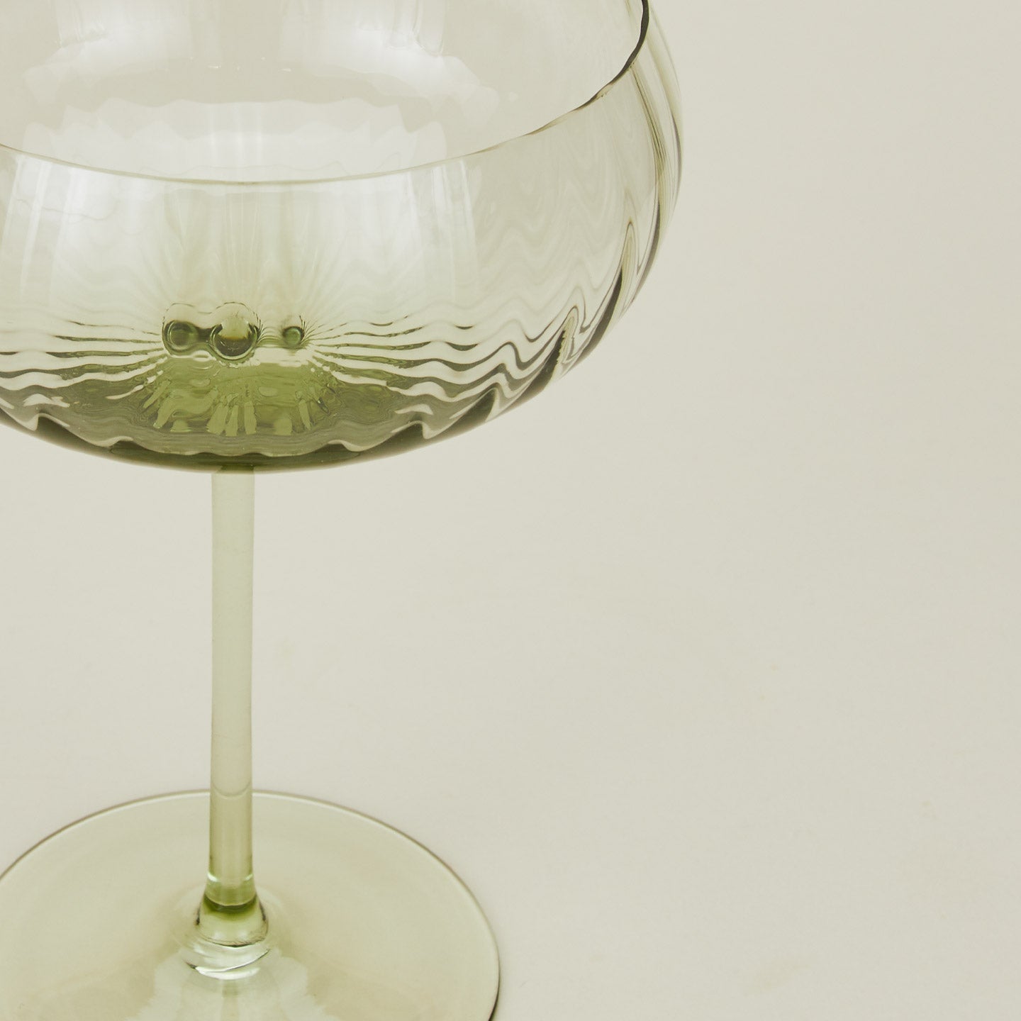 Close up of ribbed olive coupe glass.