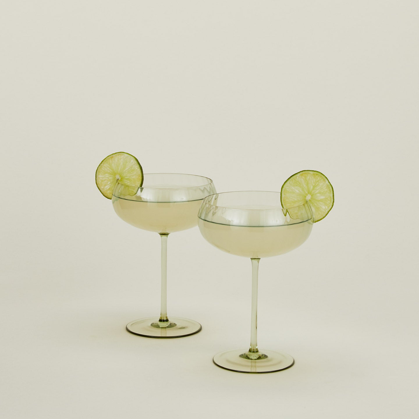 Set of two ribbed olive coupe glasses with cocktail.