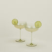 Set of two ribbed olive coupe glasses with cocktail.