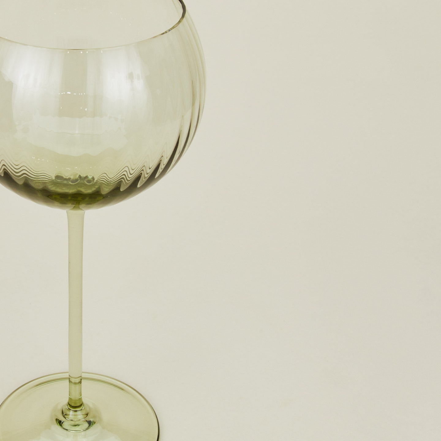 Close up of ribbed olive wine glass.