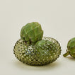 Glass hobnail olive serving bowl with artichokes.