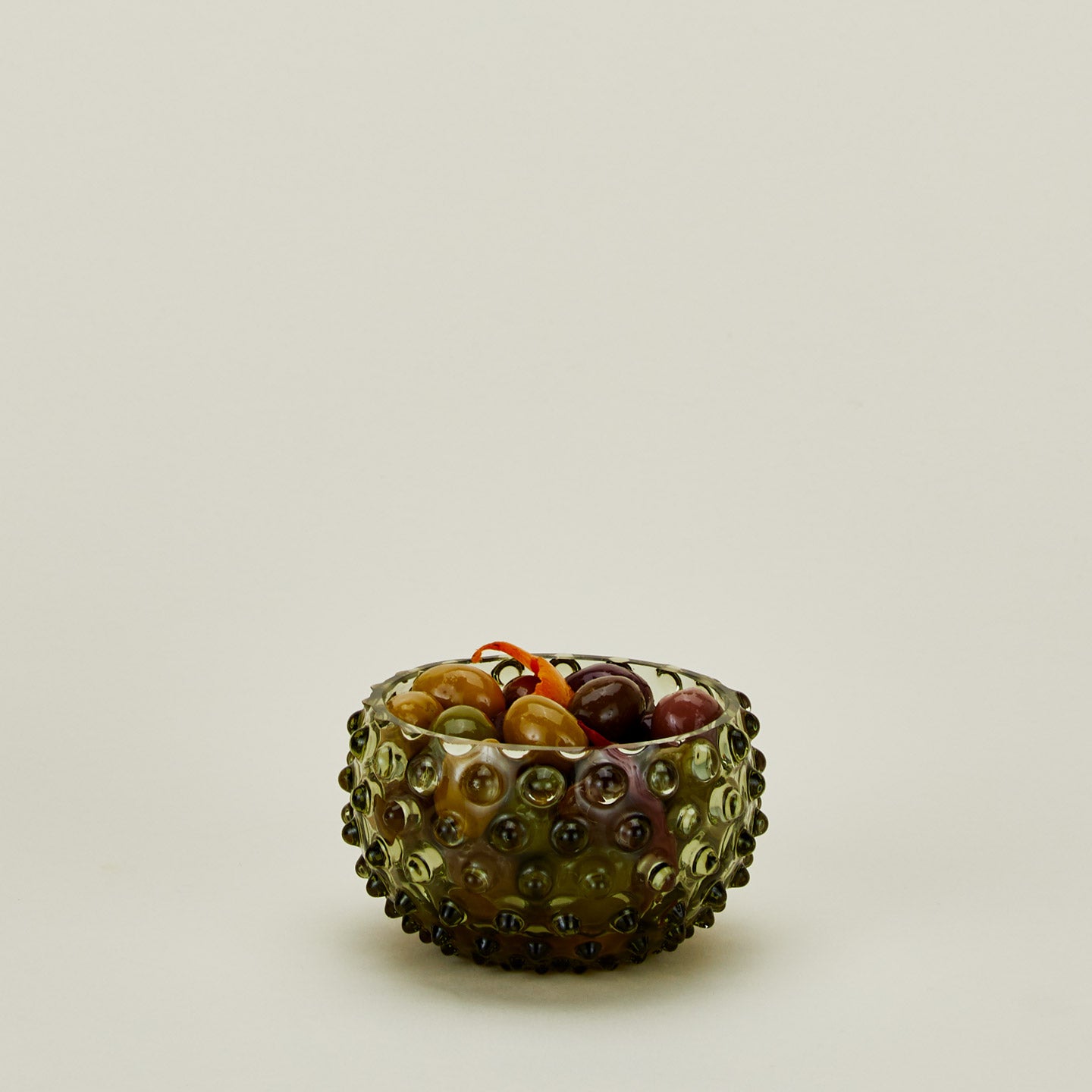 Glass hobnail olive tapas bowl with olives.