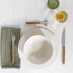 Placesetting with Atelier Small Bowl on ivory tablecloth.