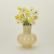 Opaque yellow glass pleated vase with flowers