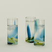 Three Blown Glass Highballs in Sky and Peacock, filled with water.