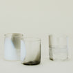 Three Blown Glass Tumblers in White and Grey, filled with ice water.