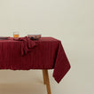 Cahaya pleated tablecloth in red on table with napkin, bowl, glassware, and plate
