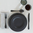 Placesetting with Checked Linen Napkin on white tablecloth.