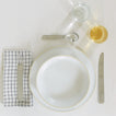 Placesetting with Checked Linen Napkin on white tablecloth.