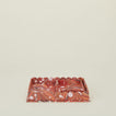 Set of two nested scalloped marbled trays in red.