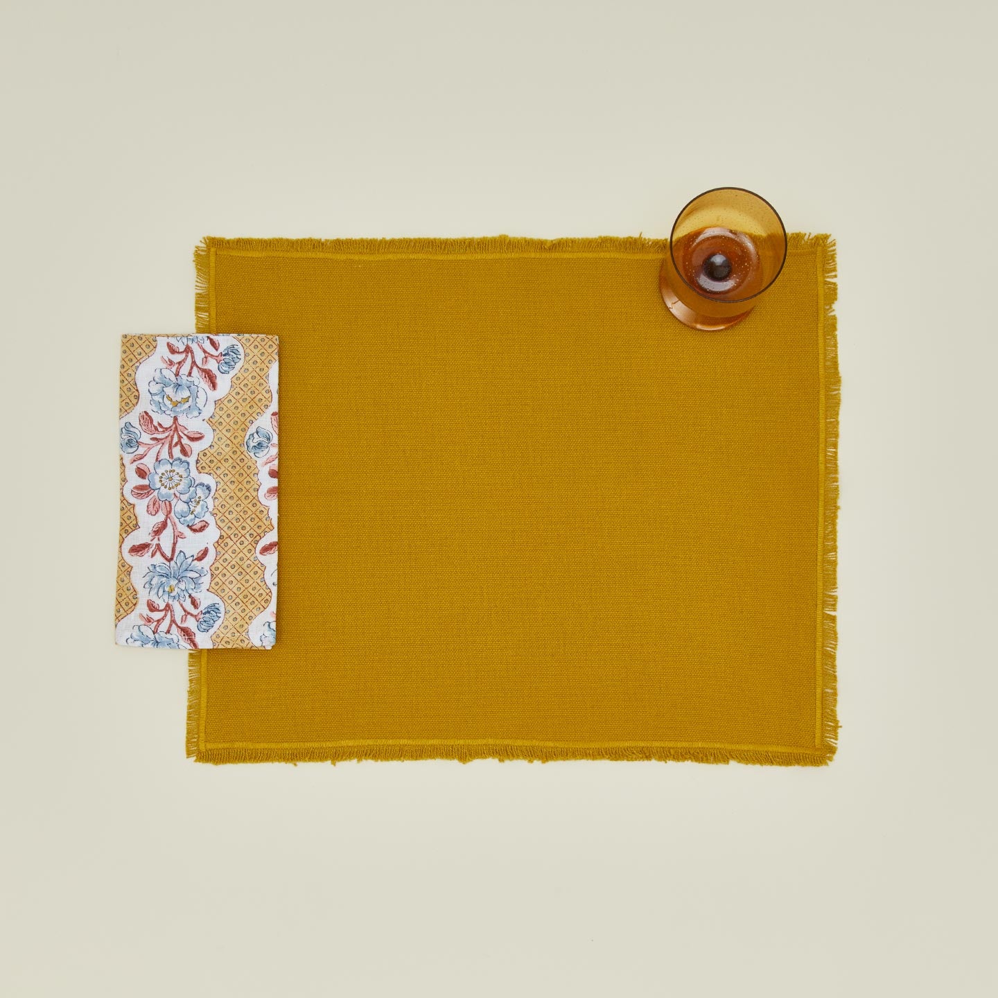 Place setting with block printed floral napkin in mustard.