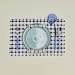 Dove and Donkey wicker fringed placemat in cobalt with place setting 